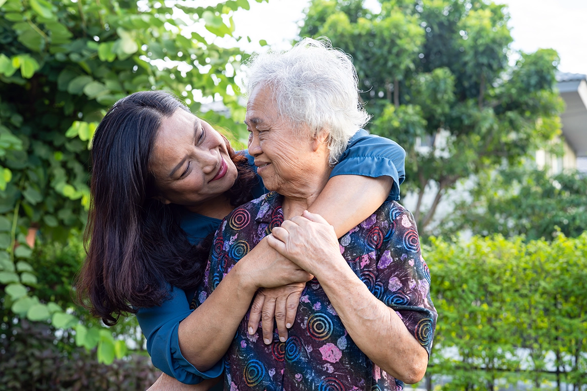 elderly woman hugging her daughter